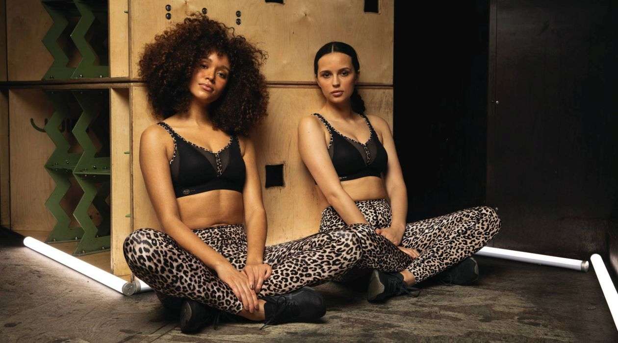 Two woman wearing Black sports bras sitting together.
