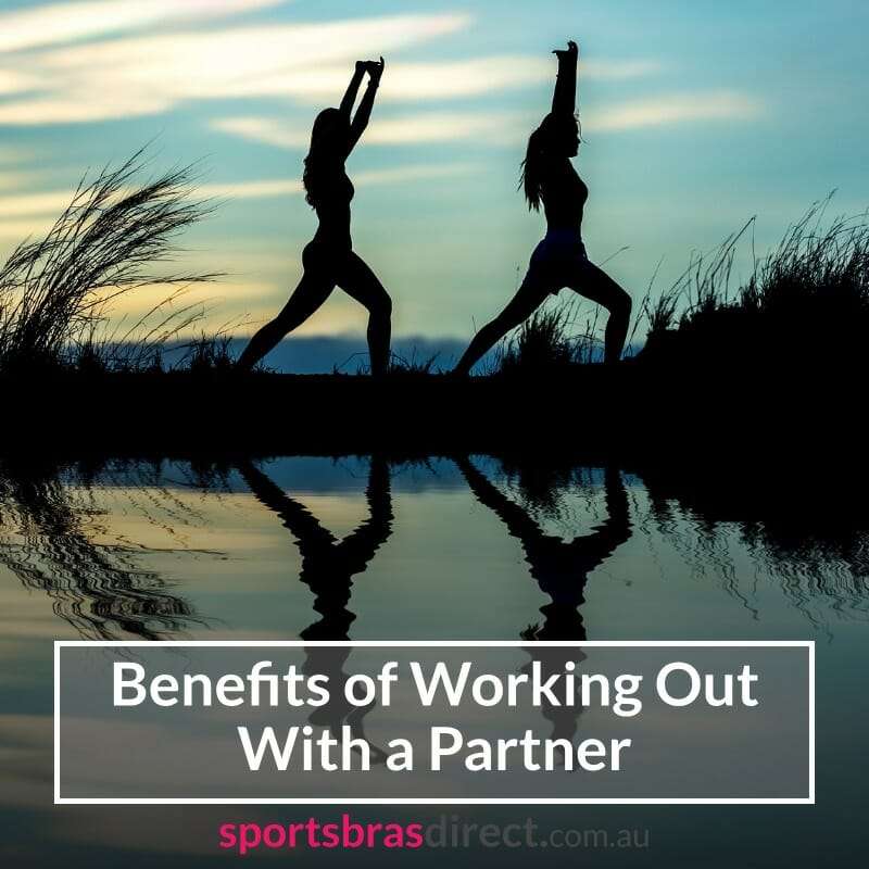 Silhouette of two women stretching by a lake.