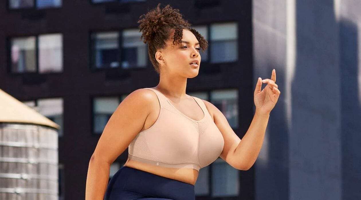 Woman power walking in a nude sports bra.