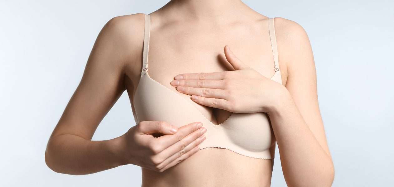 Woman adjusting her breasts in her bra.