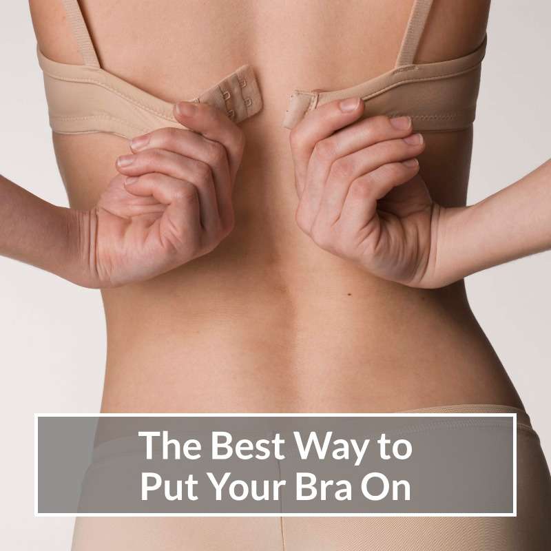 Woman doing her Nude coloured bra up at the back.