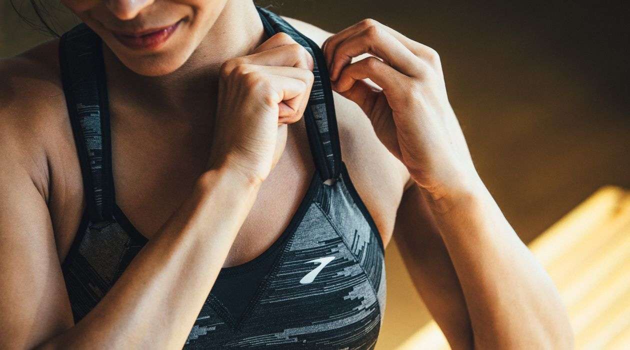 Woman adjusting her sports bra strap.