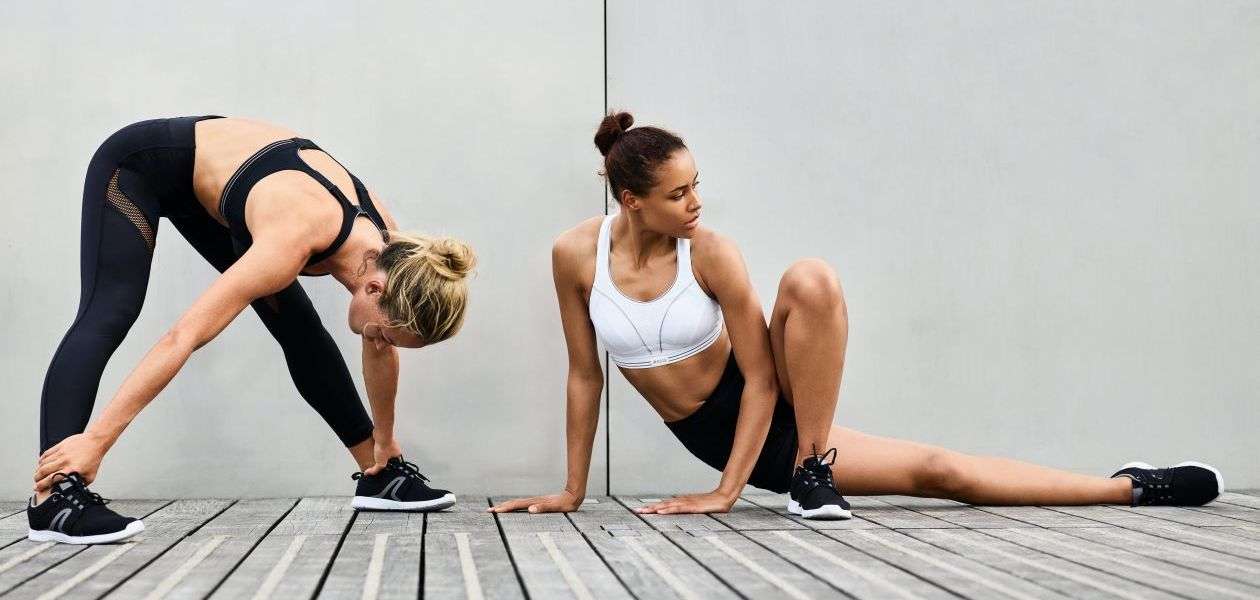 Two women stretching in active wear.