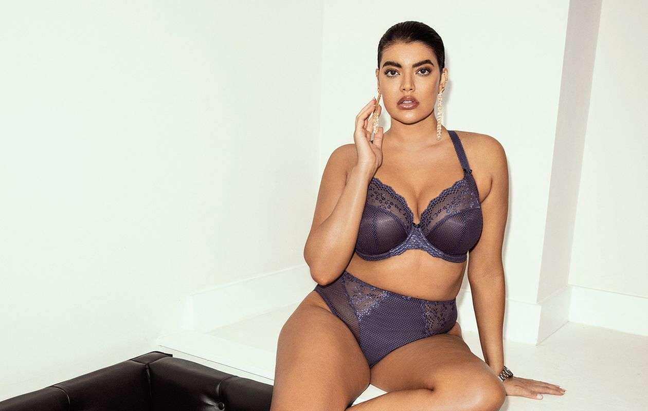 Plus size woman sitting wearing lingerie.