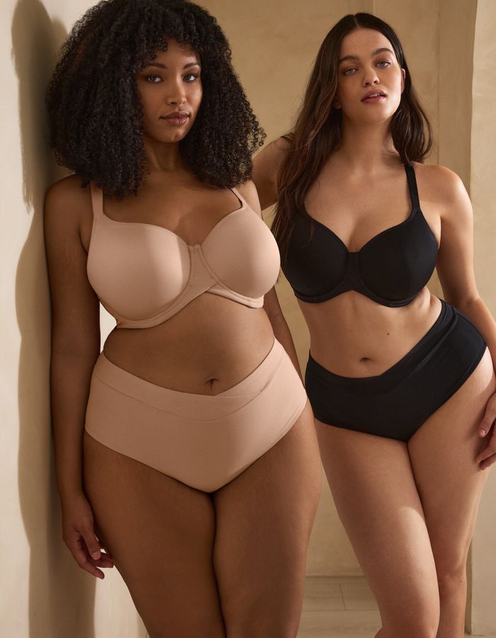 Two women wearing nude and black underwired bras with matching high-waisted briefs, showing supportive full cup styles.