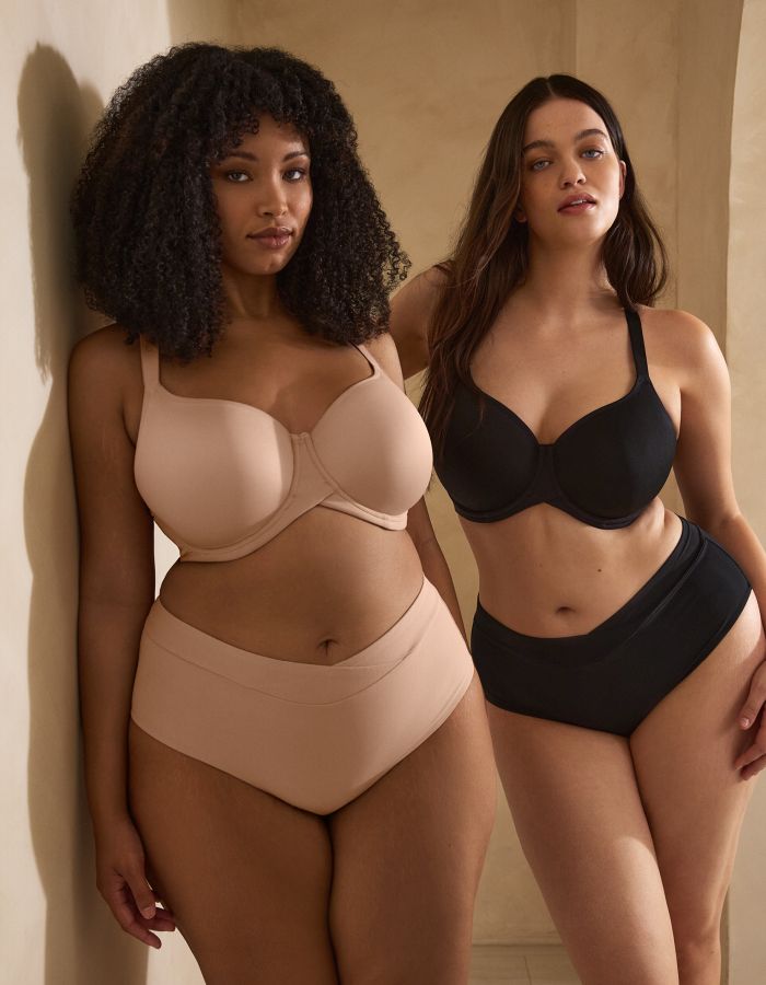 Two women wearing nude and black underwired bras with matching briefs, showing supportive full cup fits.