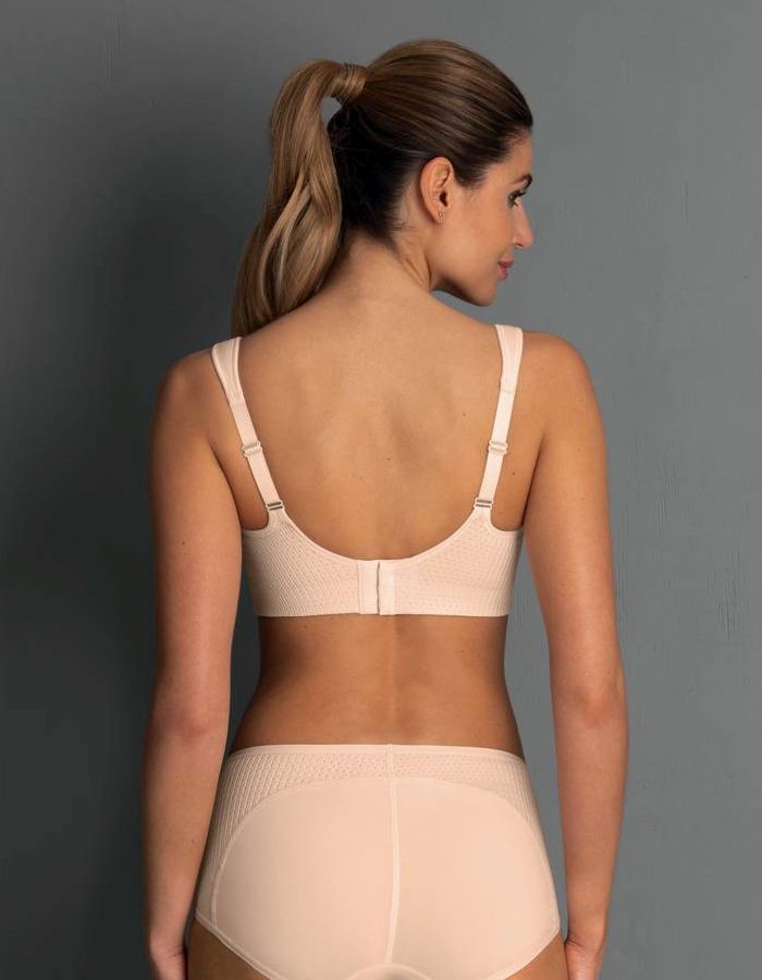 Woman shown from behind wearing a nude regular back sports bra with adjustable straps, hook closure and matching briefs.