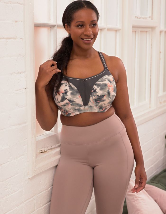 Woman wearing a supportive floral sports bra and high-waisted leggings, offering comfortable support during pregnancy.